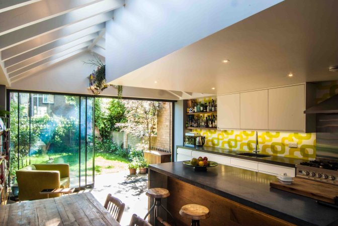 Kitchen in the Oldfield Rd rear extension with pale cabinets and wide glazing looking out to the garden